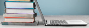 Laptop mit Buchstapel